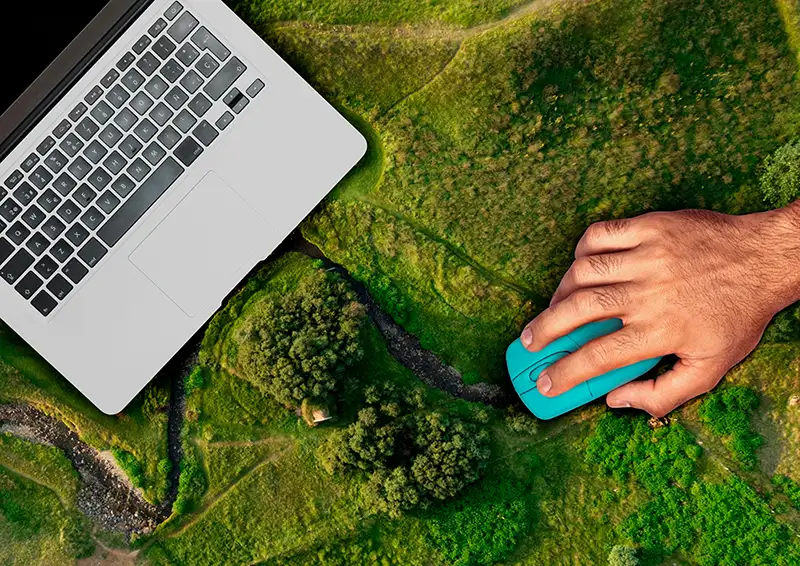 Laptop steht von oben gesehen inmitten grüner Landschaft – Symbol für Wachstum, Klarheit und nachhaltiges Webdesign